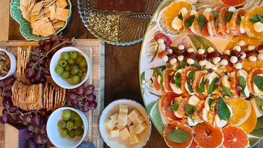 A charcuterie board from above, bright with orange, olives, cheese and pistachio